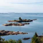 Сосны и гранитный берег отражаются в тихой воде