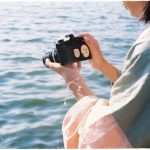 Камера и контактные отпечатки на рабочем столе фотографа