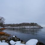 заснеженный каменистый берег у тёмной ладожской воды