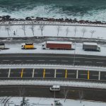 Грузовики движутся по заснеженной ледовой дороге