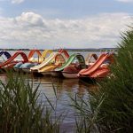 Семья у лодки на берегу большого озера